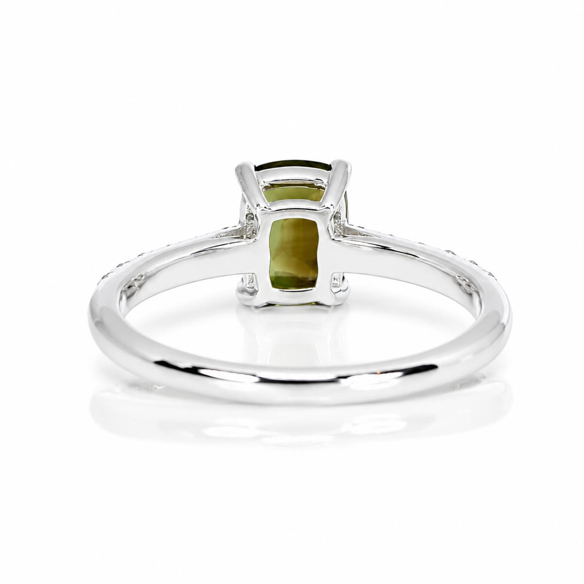A white gold ring featuring a natural alexandrite in a prong setting, shown on its back view on a clean white background with a soft reflection.