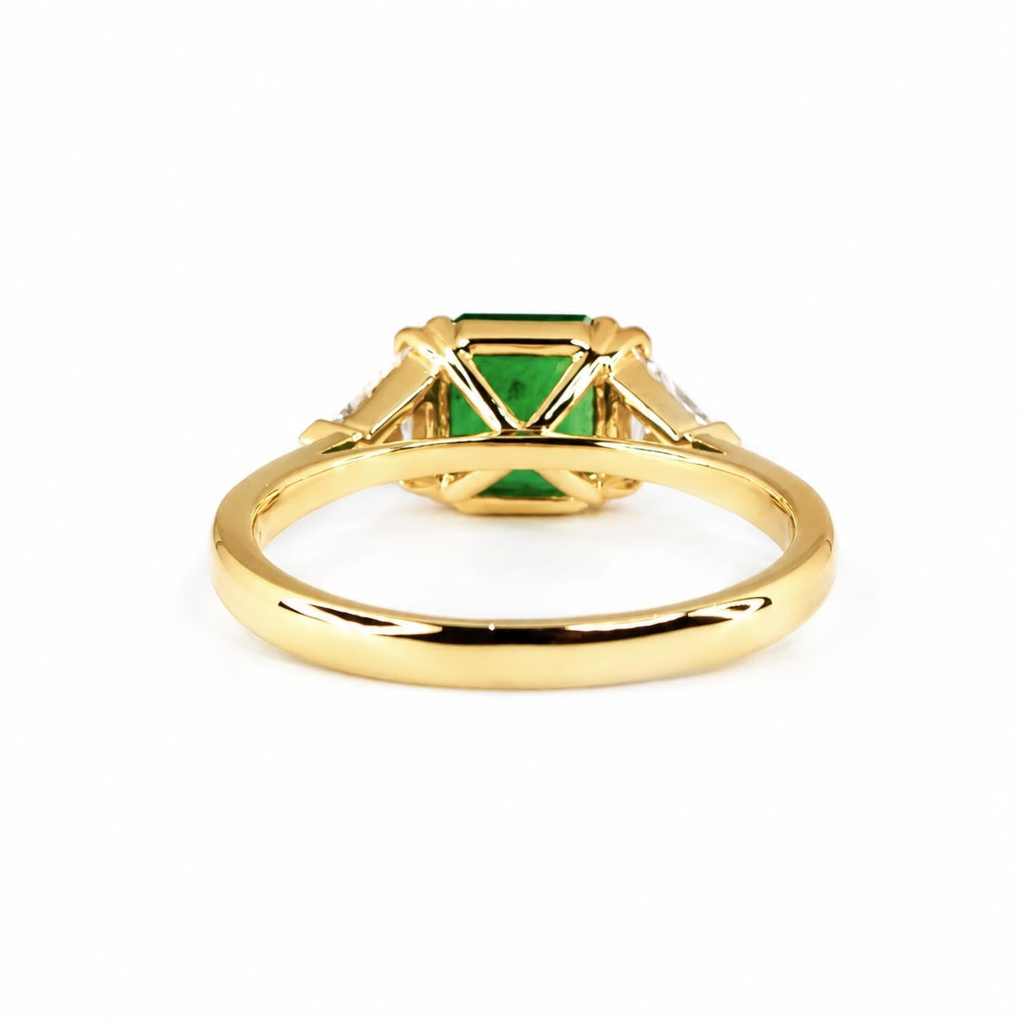 Side view of Colombian emerald and trillion diamond ring in 18K yellow gold
