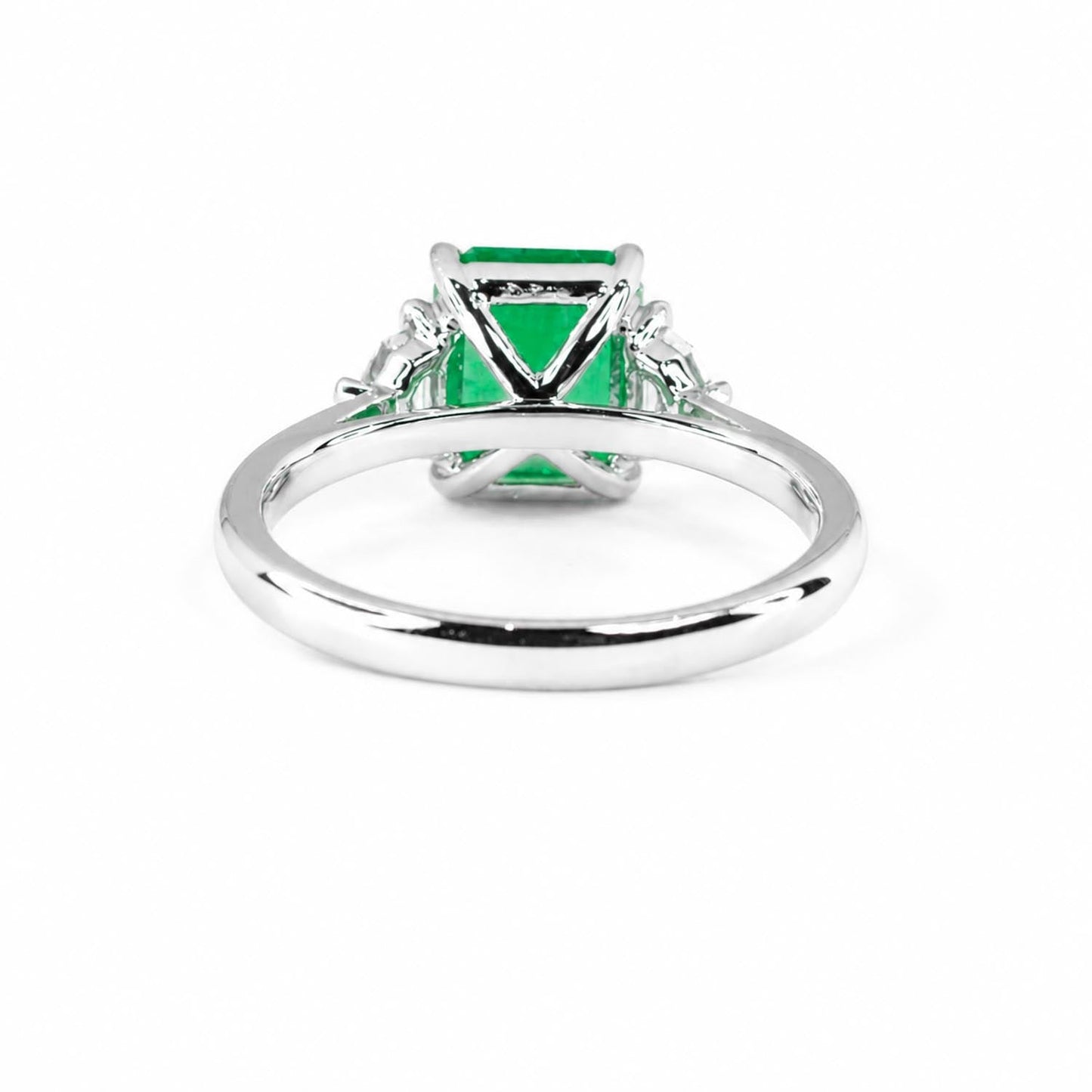 Side view of emerald cut three stone ring in 18K white gold