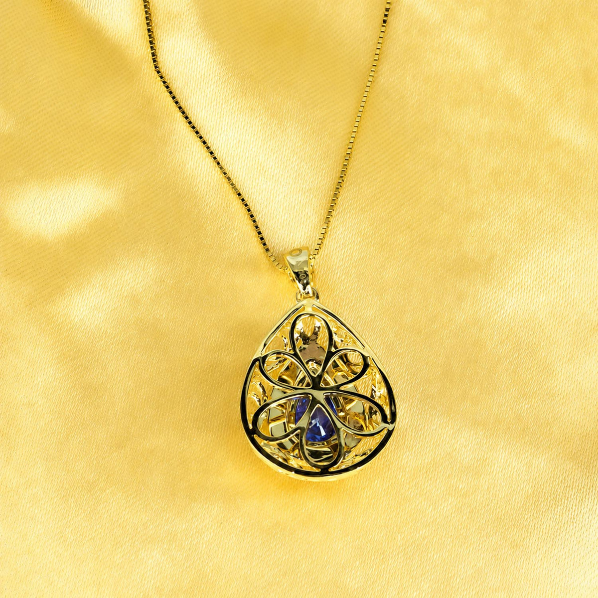 Blue sapphire pendant with diamond set bail in 18K yellow gold