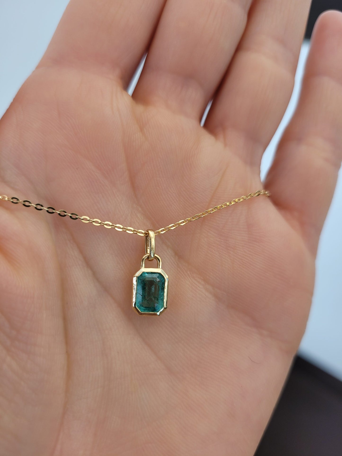 0.91ct Natural Elongated Emerald Cut Emerald Pendant view on hand