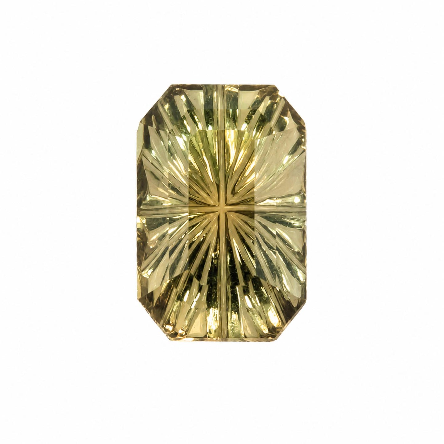 A faceted fantasy cut sapphire with a starburst or sunburst cut pattern, showing a warm yellow-green color, isolated on a solid white background.