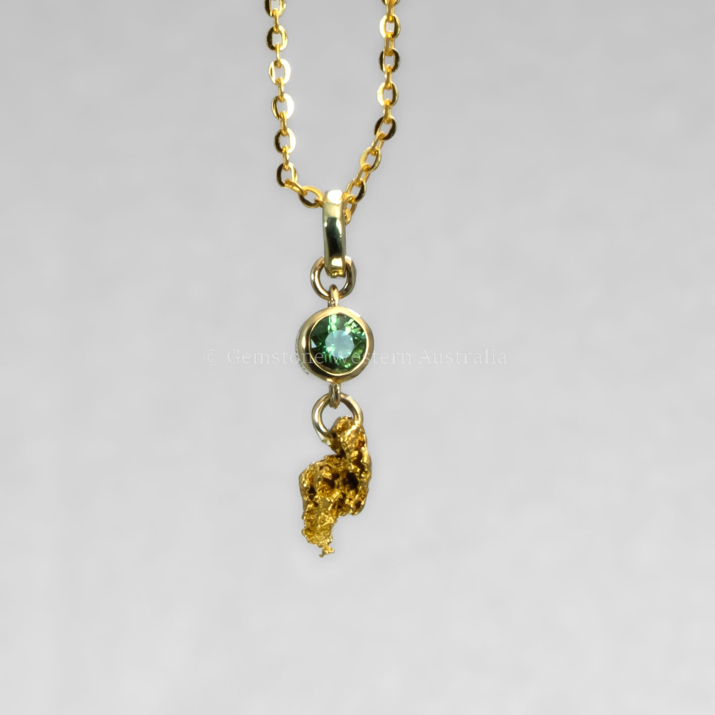 photo on hand of second sapphire and gold nugget pendant