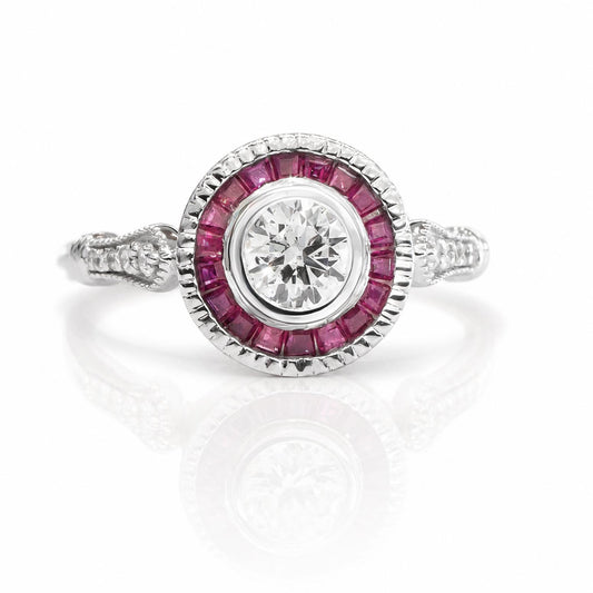A white gold diamond ring featuring a round-cut center diamond surrounded by a halo of custom cut baguette rubies, with accent sise diamonds on the band, shown on a white background with a soft reflection.