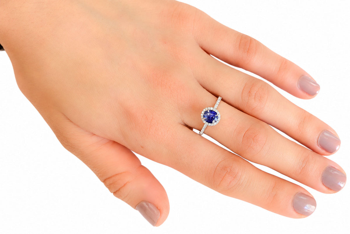 Ceylon sapphire and diamond halo ring worn on the hand