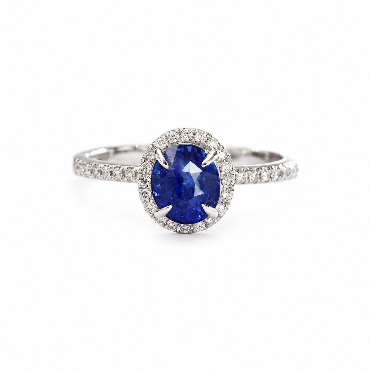 Oval Ceylon sapphire ring with diamond halo and pave band, angled view