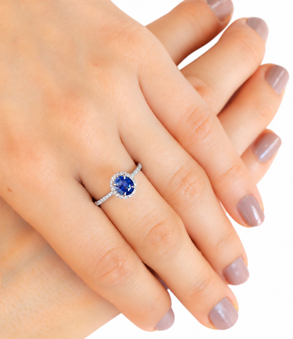 Ceylon sapphire and diamond ring worn, hands resting together