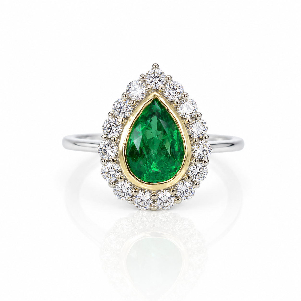 A pear-cut Colombian emerald ring featuring a vibrant emerald center stone surrounded by a halo of diamonds, set in yellow gold, on a polished white gold band, shown on a white background with a soft reflection.