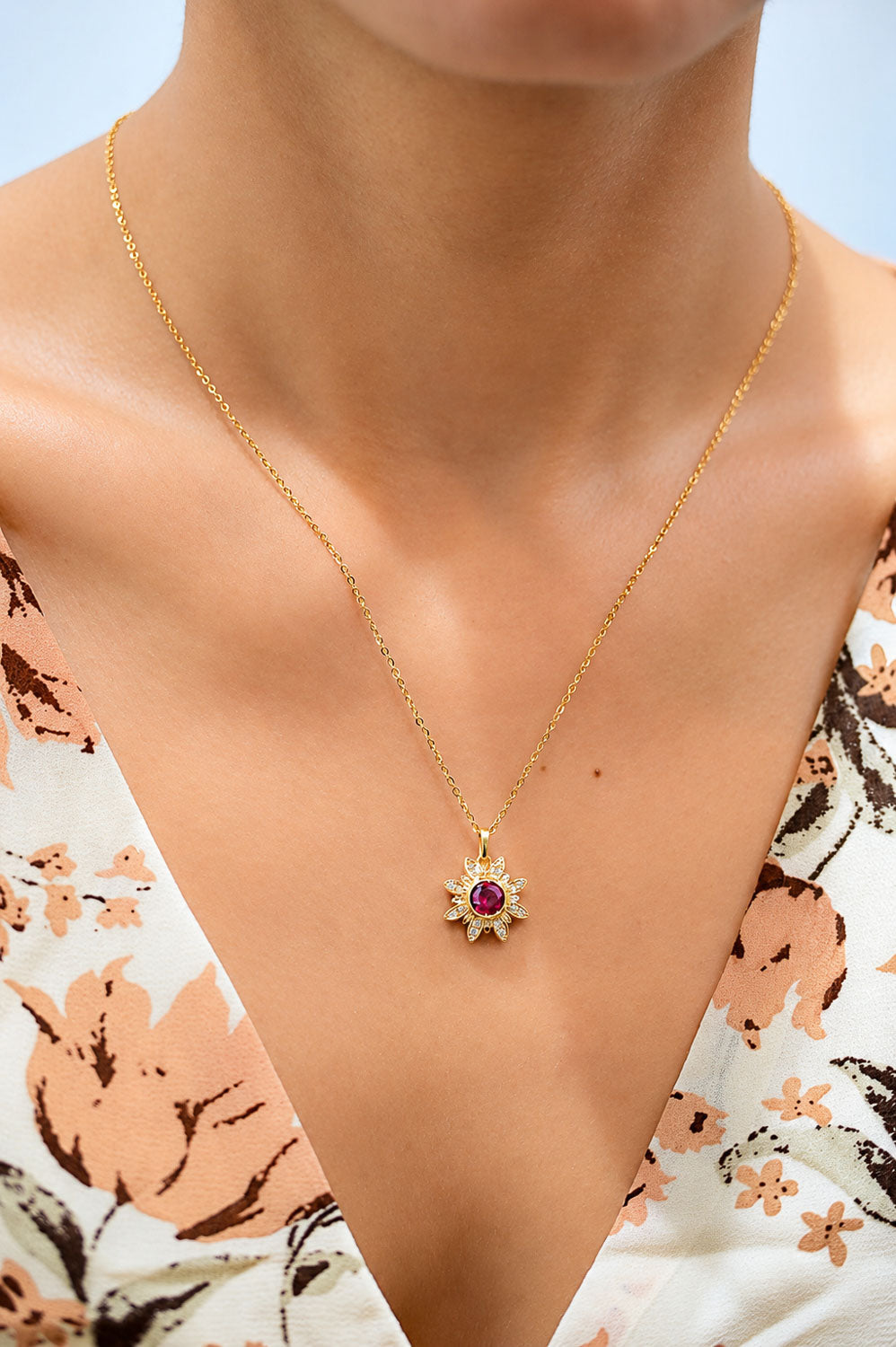 Orangy red sapphire flower pendant worn on the neck
