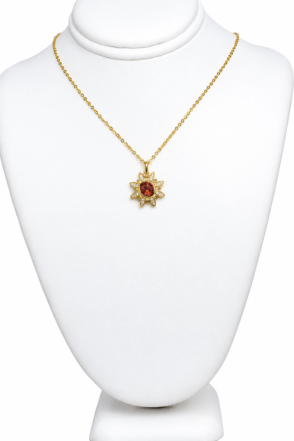 Flower pendant displayed on a jewellery bust with its gold chain
