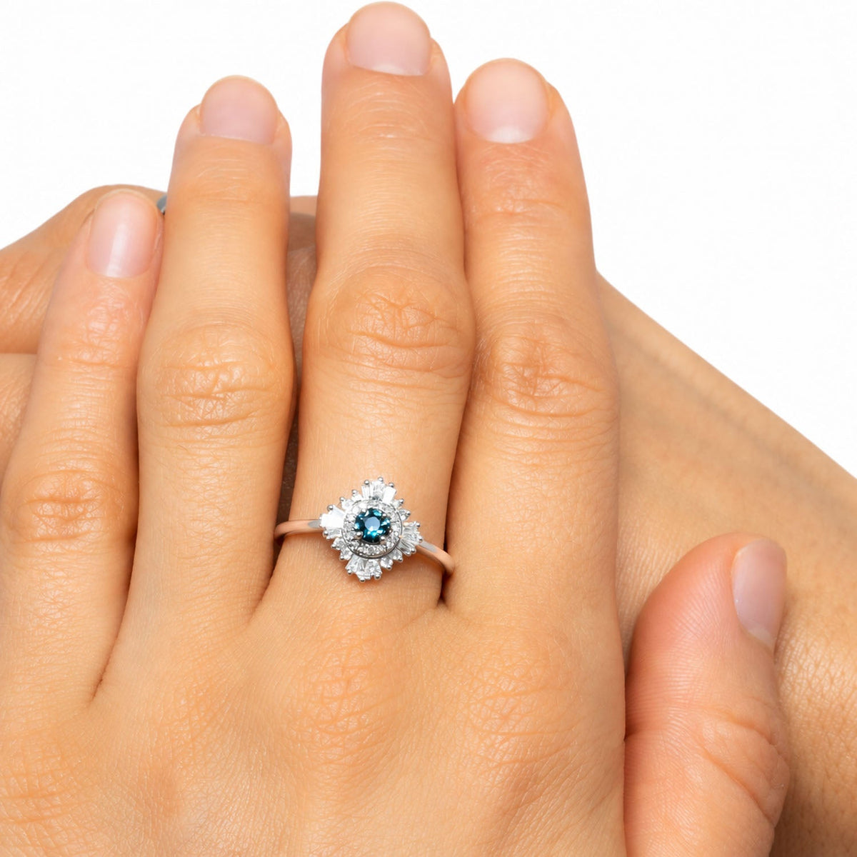 Teal sapphire halo ring worn on the hand