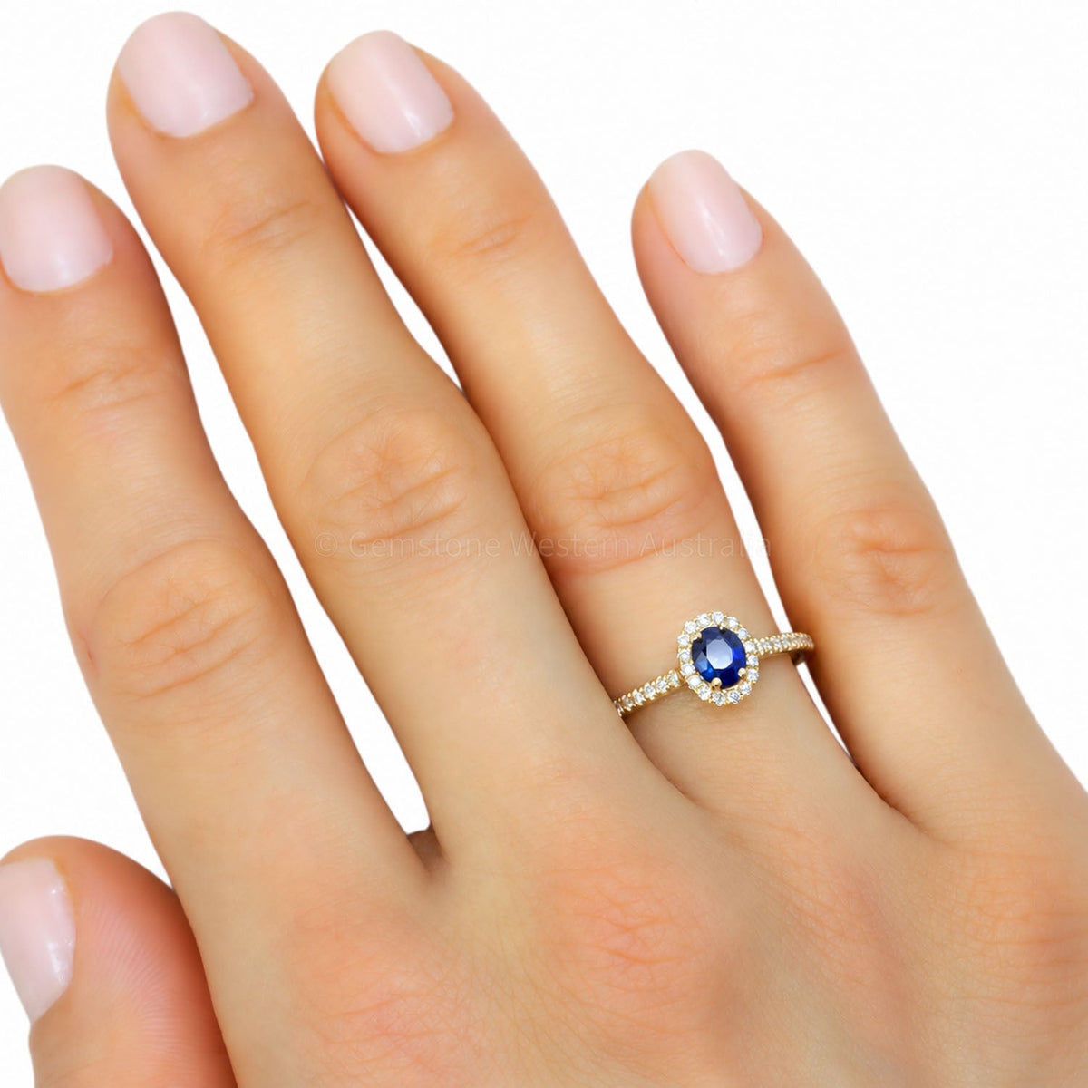 Blue sapphire halo ring worn on the hand
