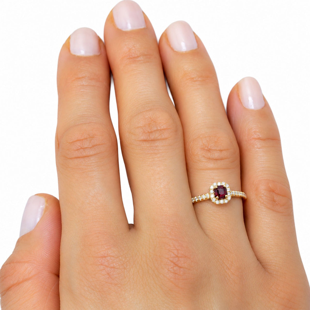 Ruby and diamond halo ring worn on the hand