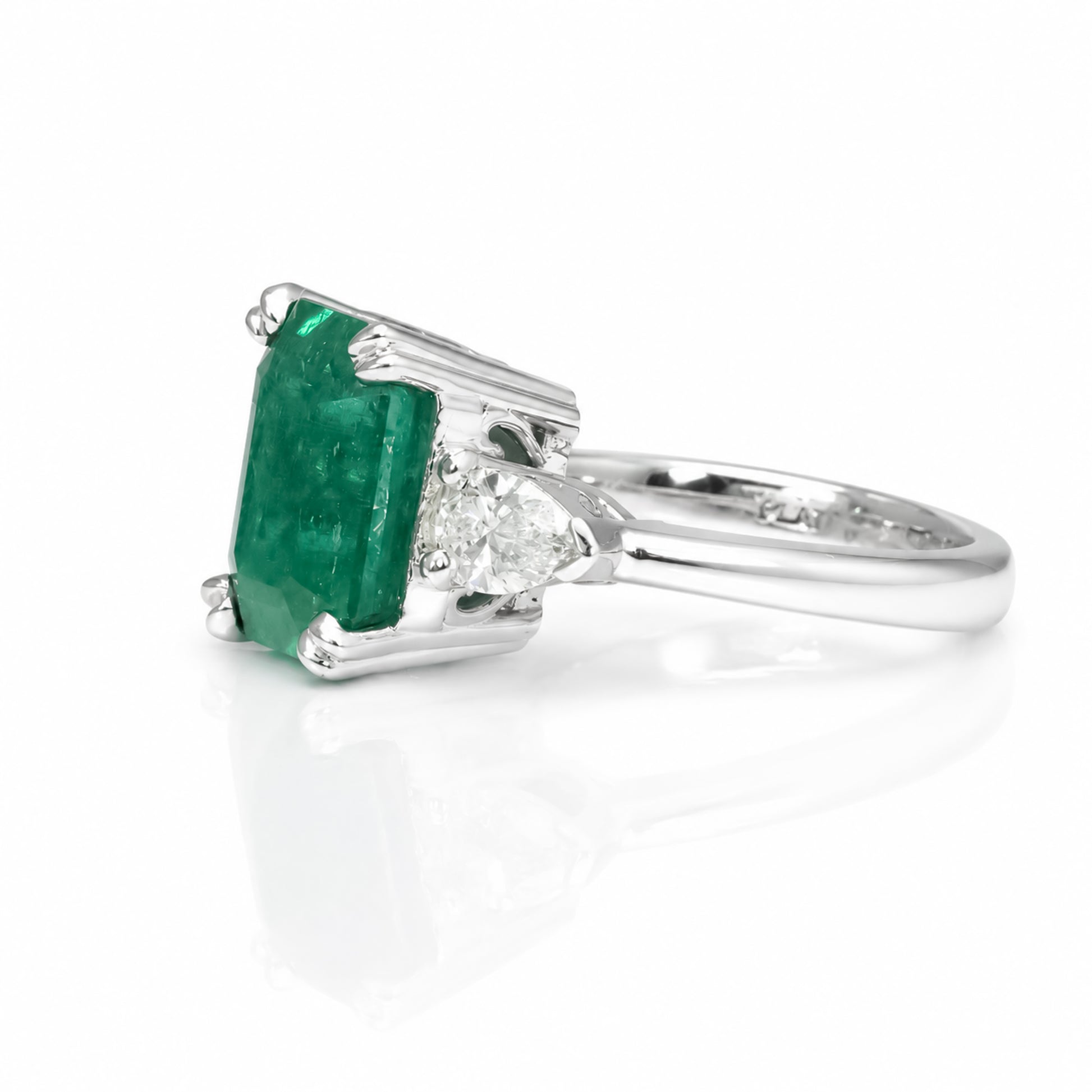 side view of a 6.46 Carats Colombian Emerald and Diamond Statement Ring with GIA Certified diamonds in a white background