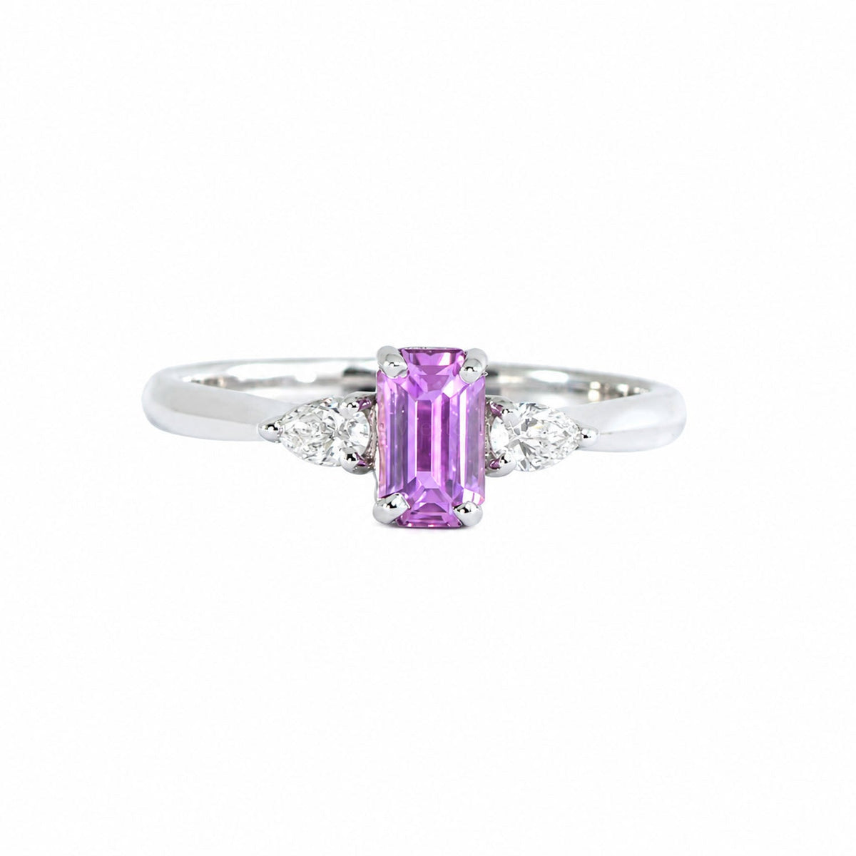Emerald-cut pink sapphire three stone ring, angled view