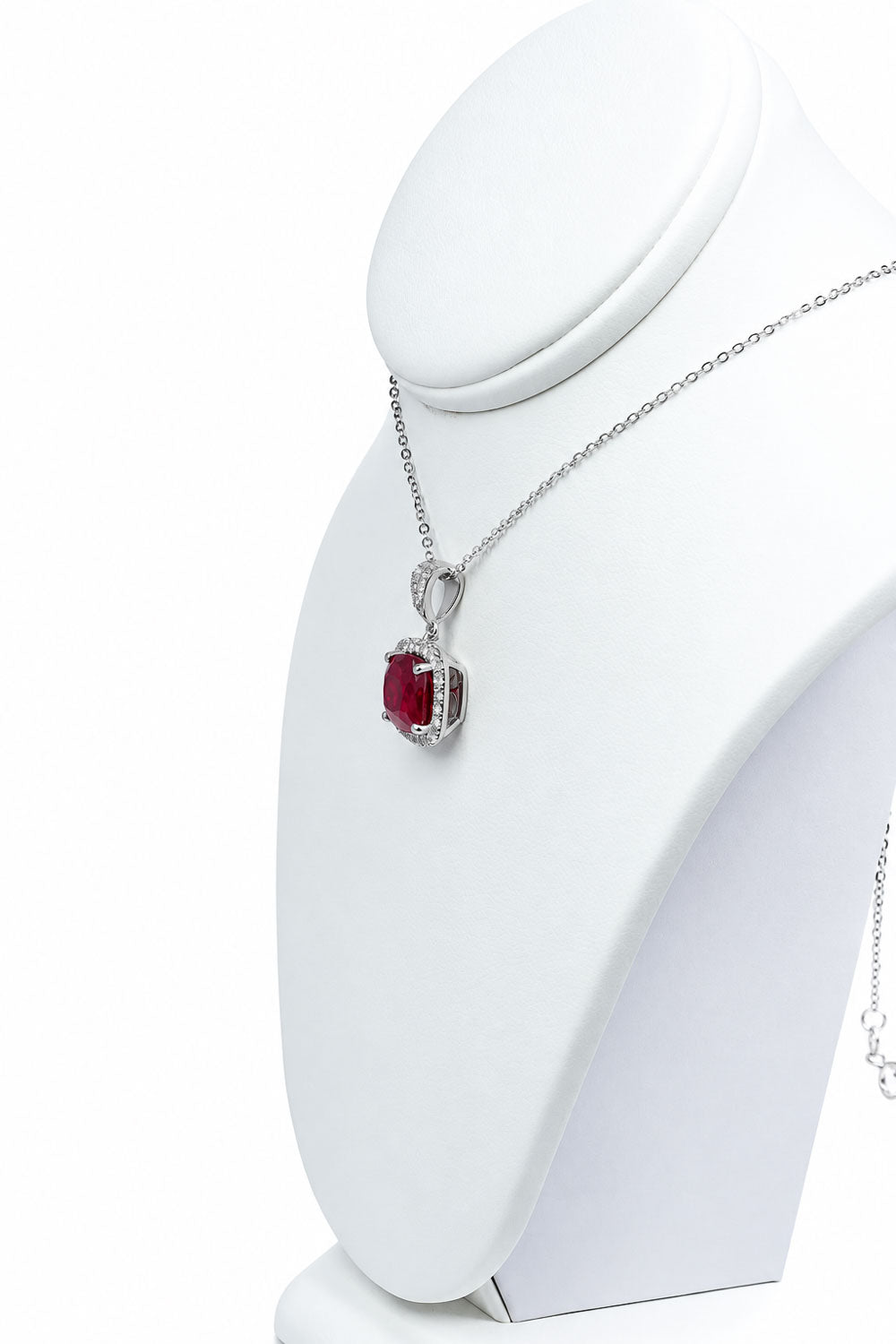 Side view of the ruby halo pendant on the display bust