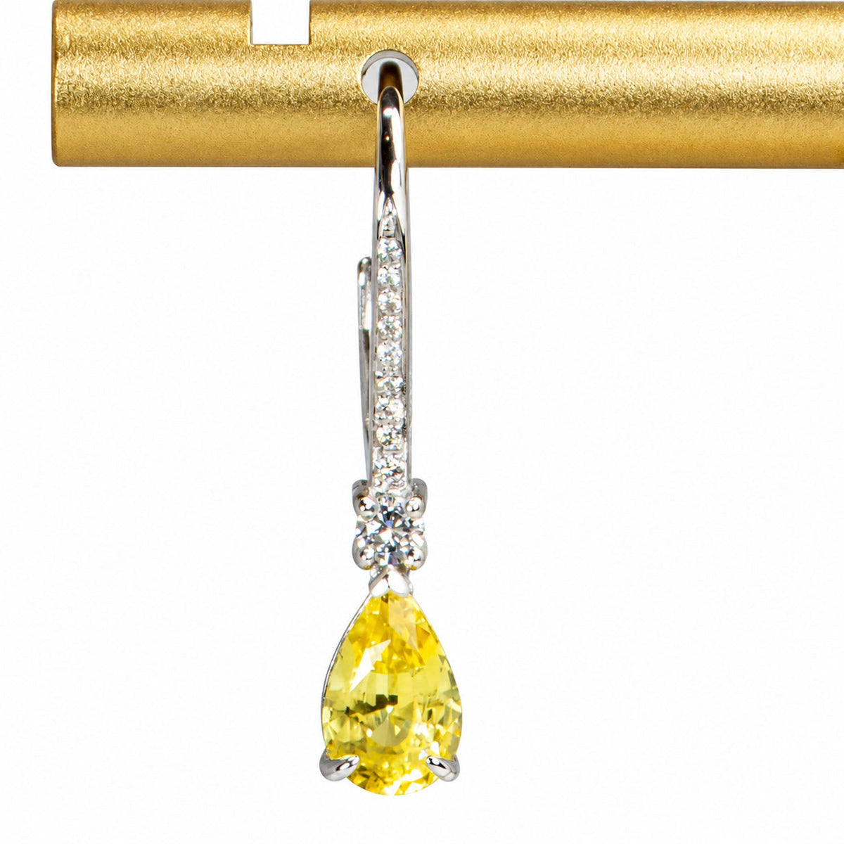 Close view of one yellow sapphire drop earring and its diamond-set bar