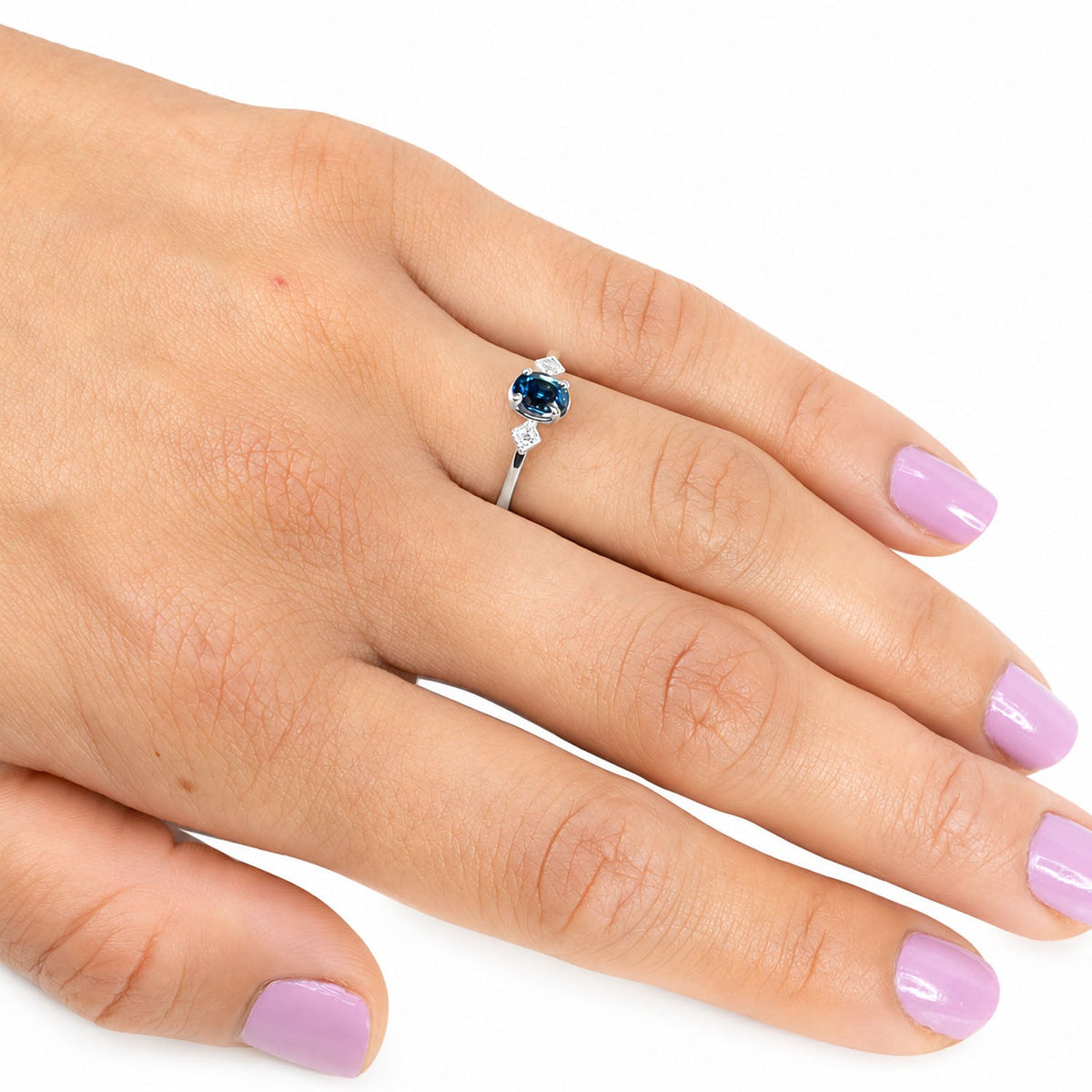 Teal sapphire and diamond ring worn on the hand