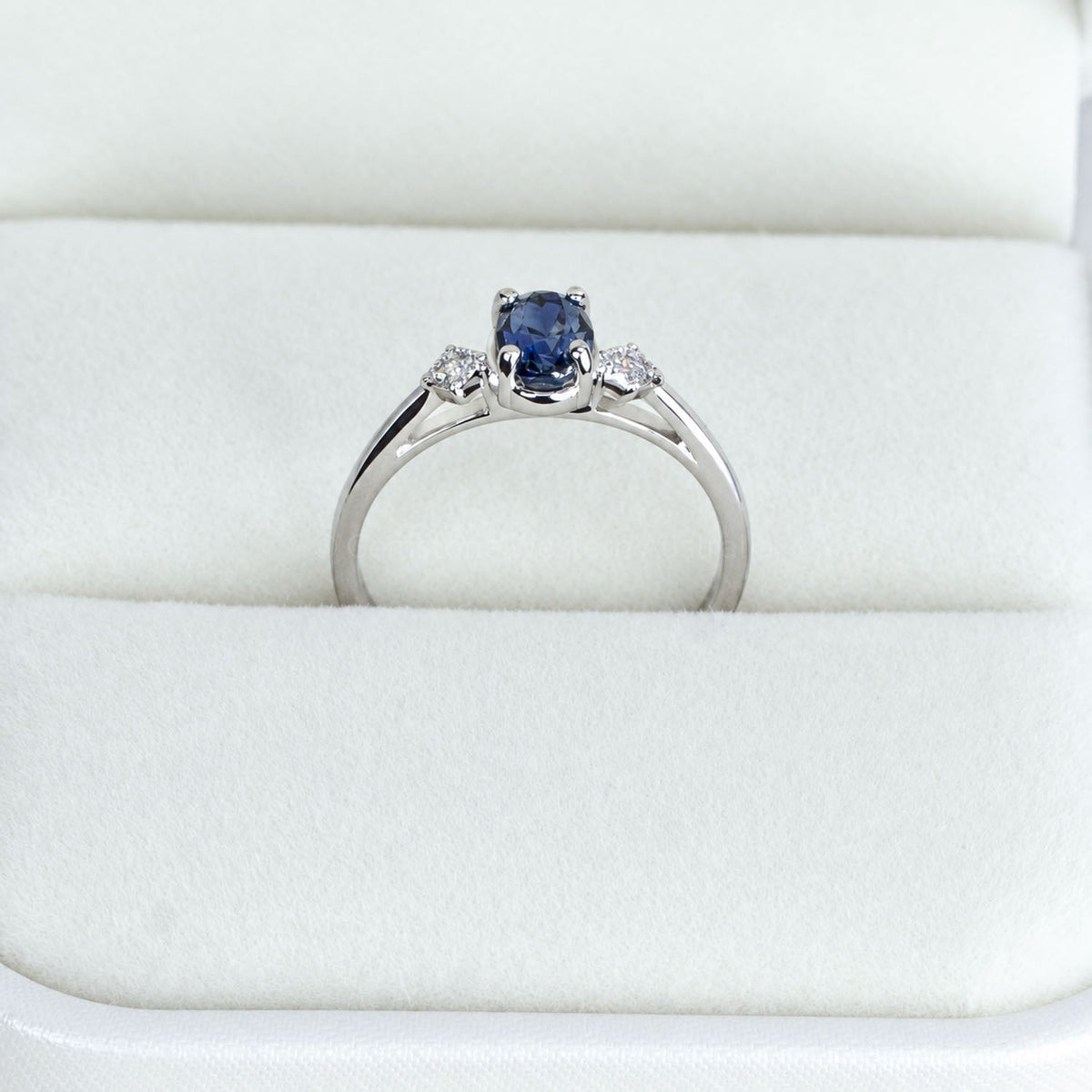 Close view of the teal sapphire ring standing in its box
