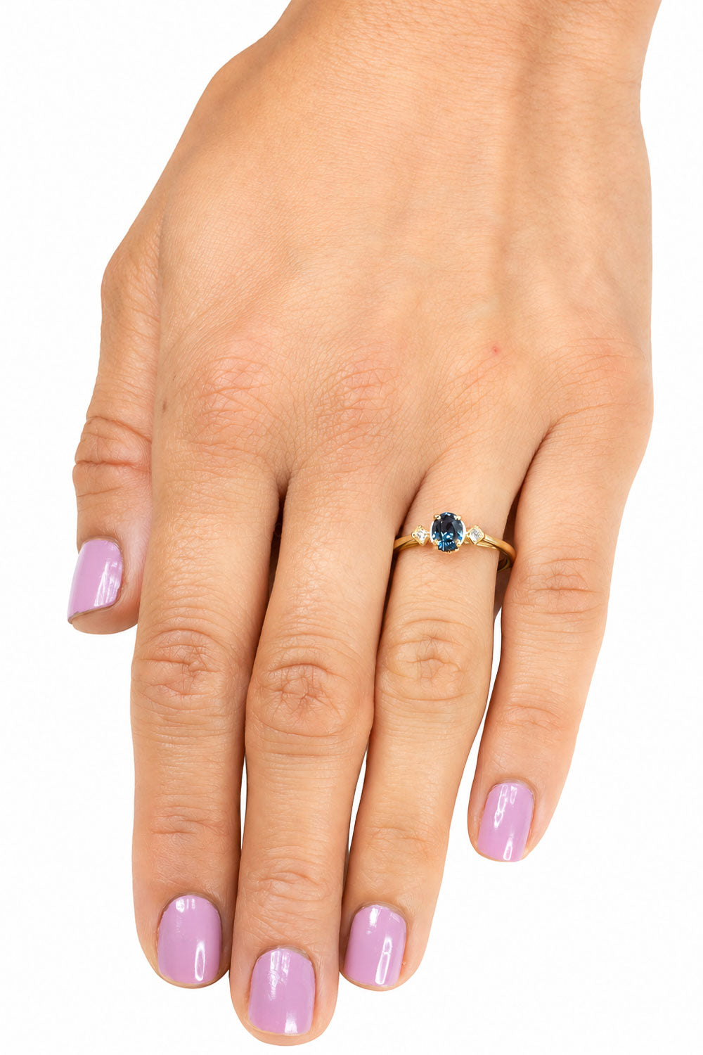 Teal sapphire ring worn, hand resting