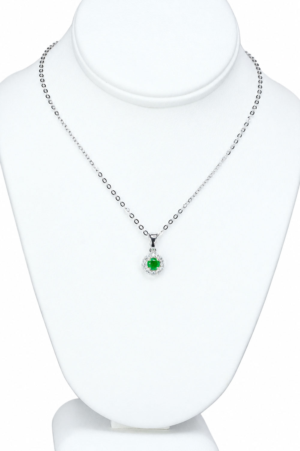 Colombian emerald halo pendant displayed on a jewellery bust