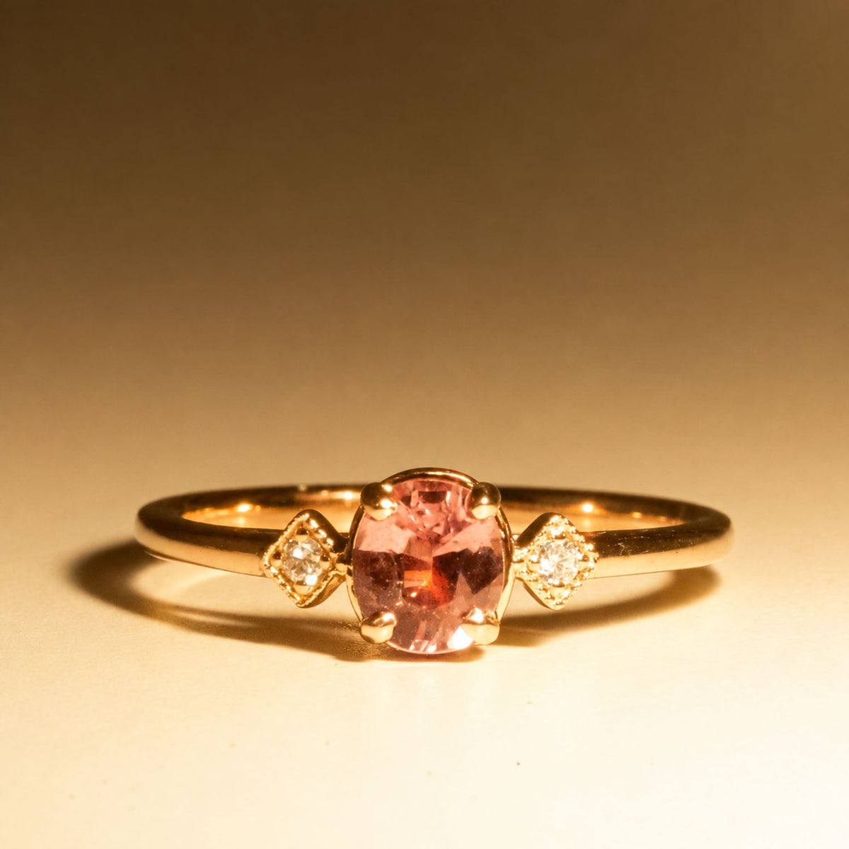 The same alexandrite ring under warm light, showing its pink colour change