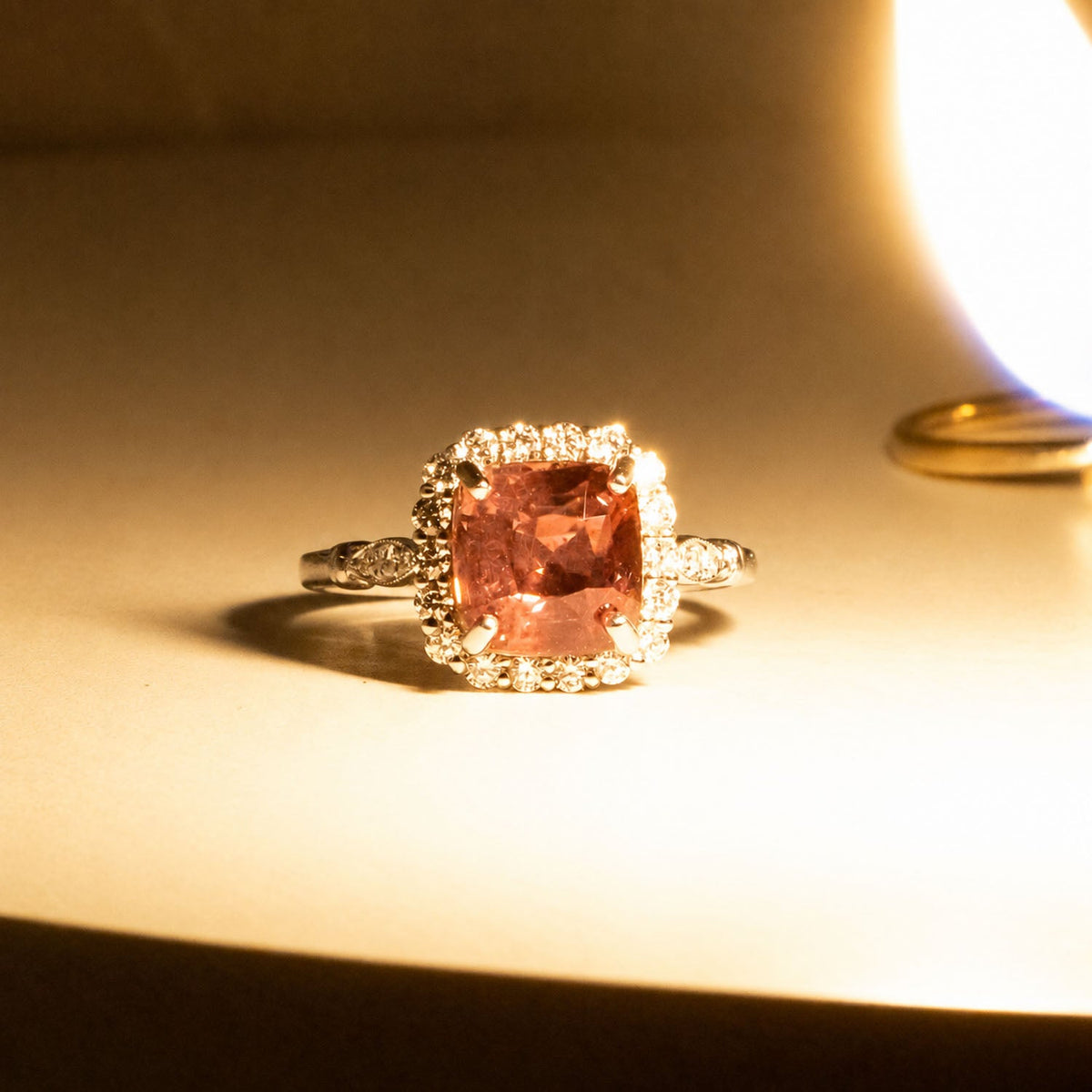 Alexandrite halo ring photographed beside a warm light source