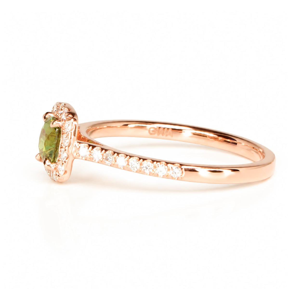 Side view of a rose gold ring with a natural cushion cut alexandrite that is surrounded by a halo of diamonds and additional diamonds cascading on the band in a white background
