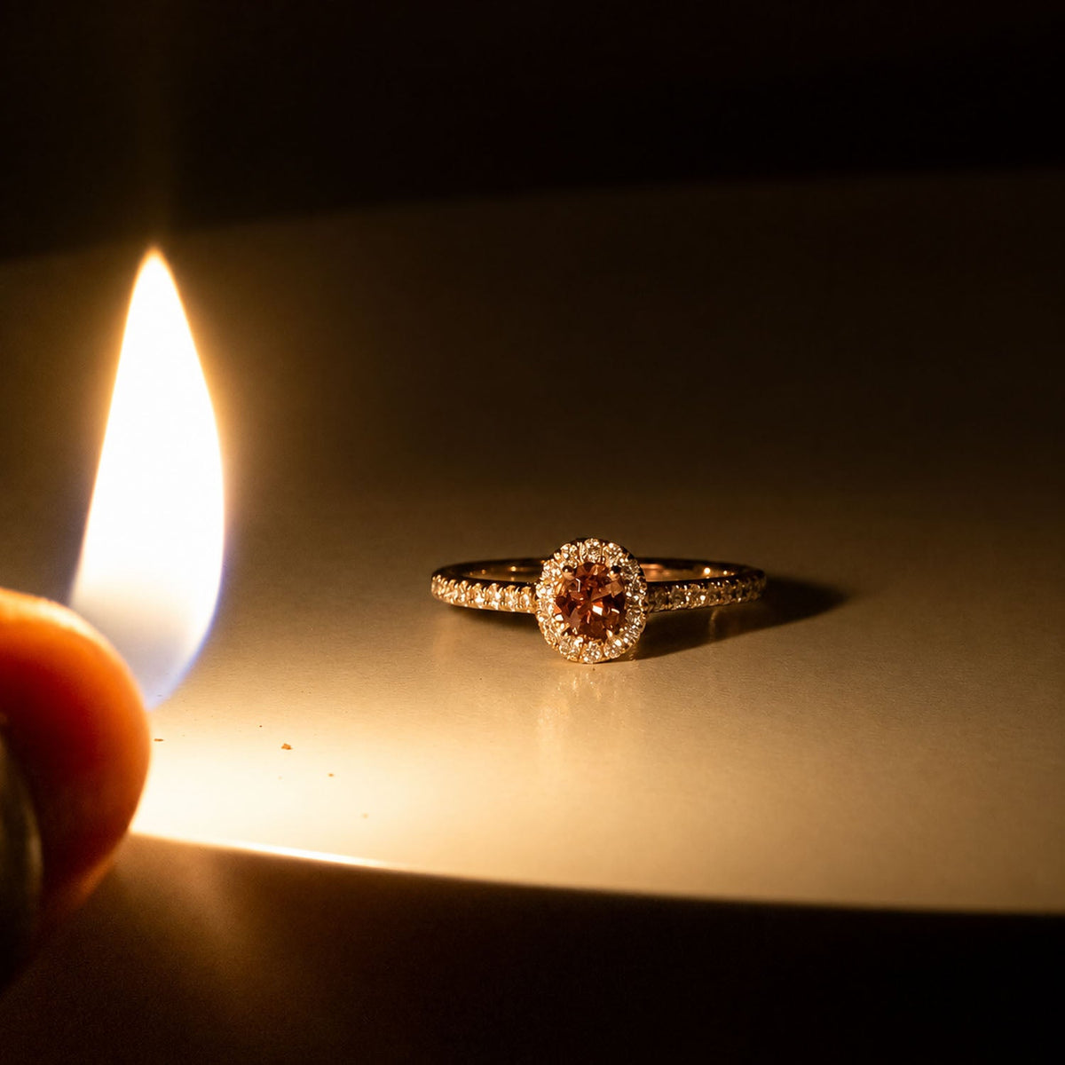 Alexandrite ring beside a candle flame, colour changed to pink