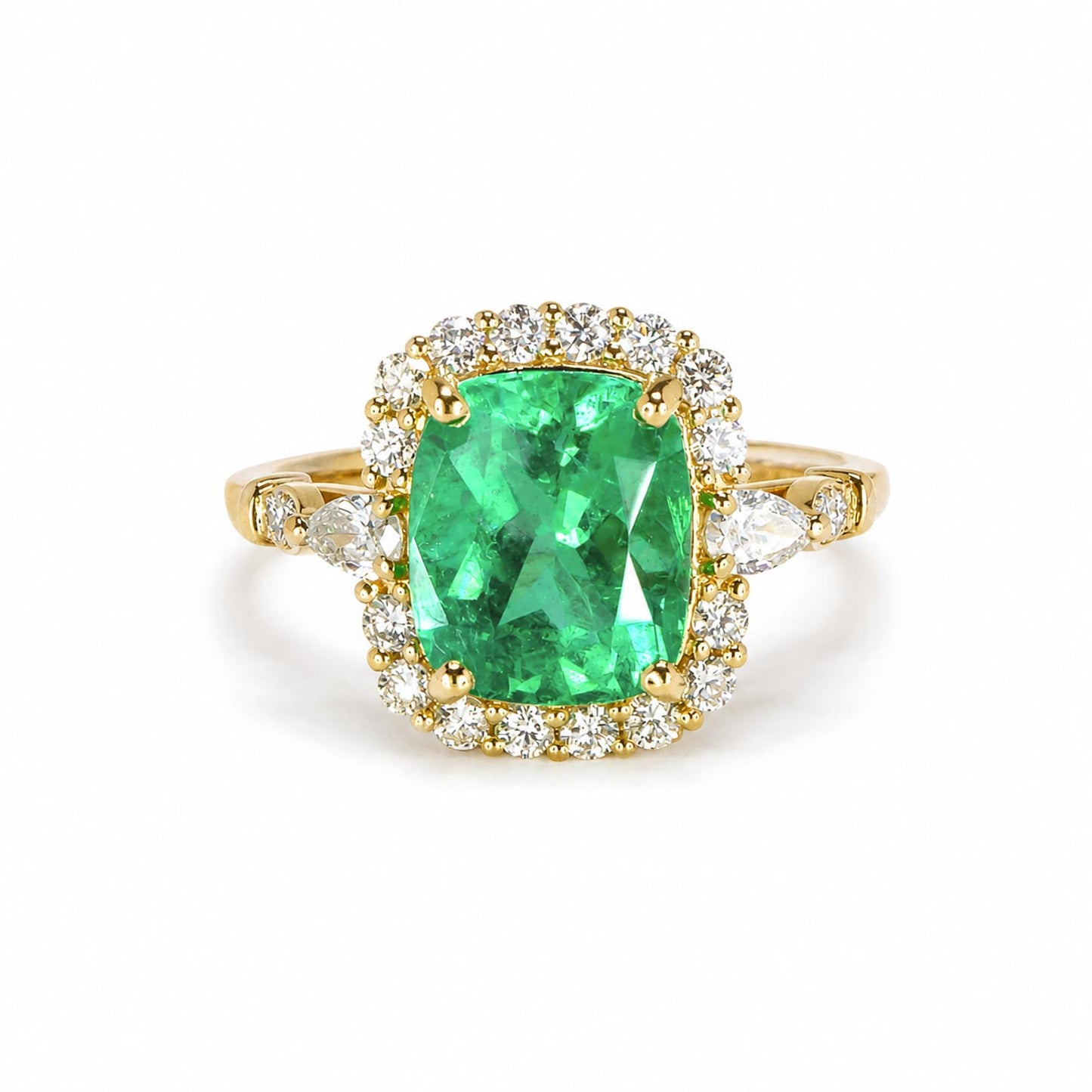 A yellow gold ring featuring a large cushion-cut natural Colombian emerald surrounded by a halo of round brilliant cut diamonds, with additional diamonds set along the shoulders of the band, shown on a plain white background.