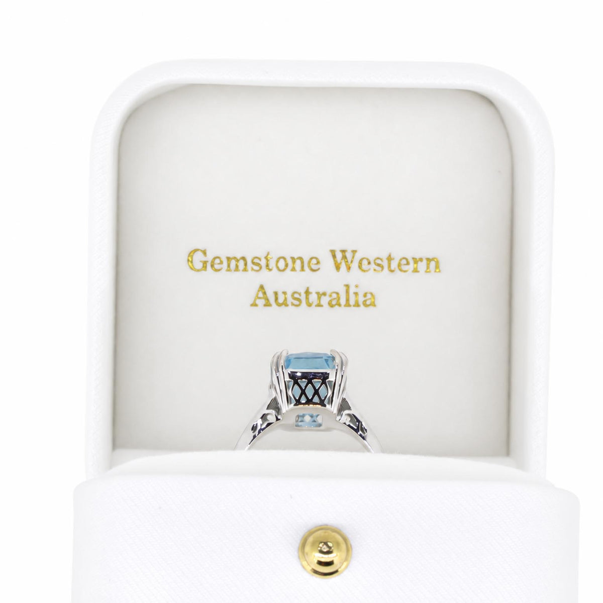 Side view of a white gold ring holdings an octagon cut aquamarine as a centre gemstone shown in a white ring box with gold letters that say "Gemstone Western Australia"