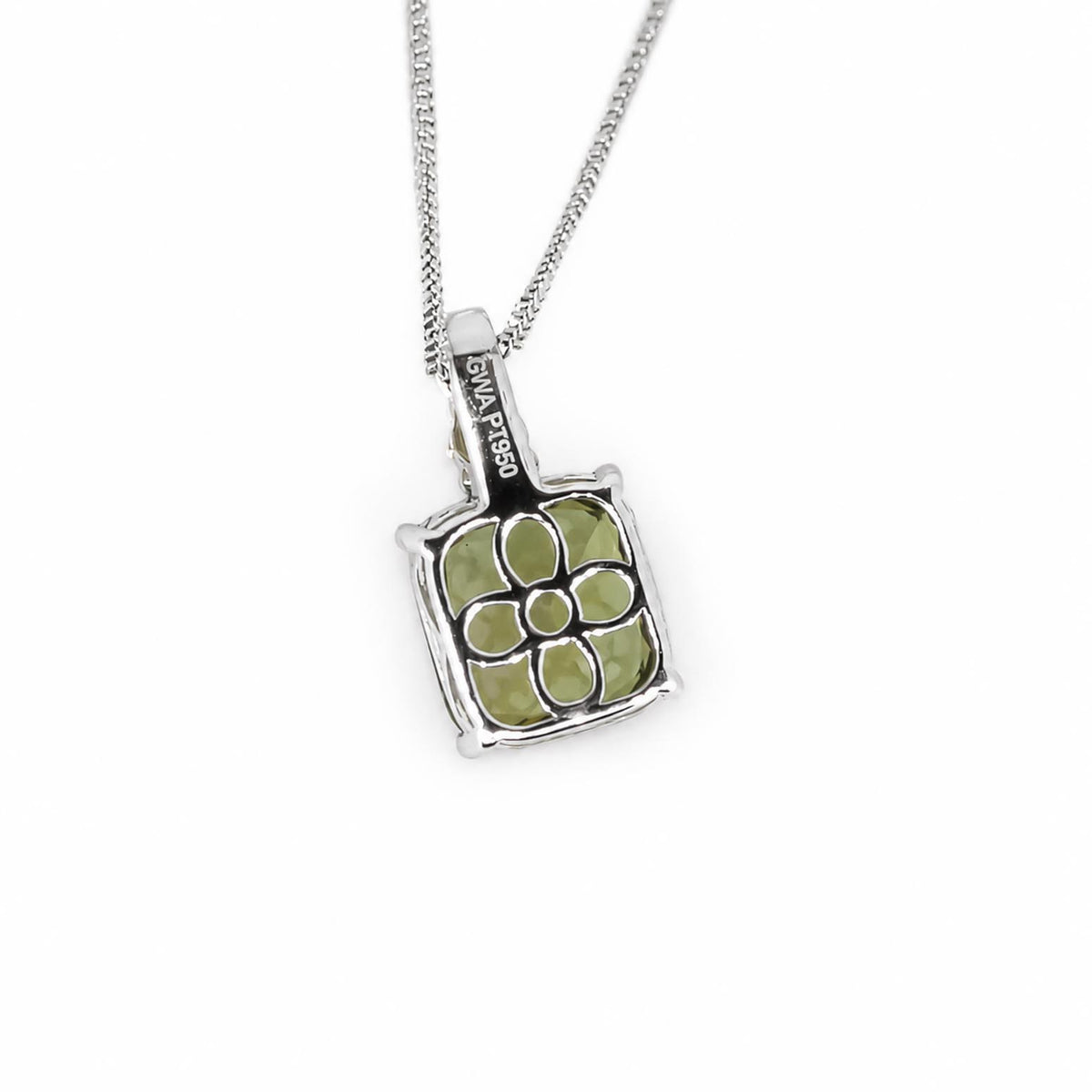 back view of a platinum pendant holding a natural green sapphire suspended from a platinum chain showing the back side of the pendant with a flower design shown on a white background 
