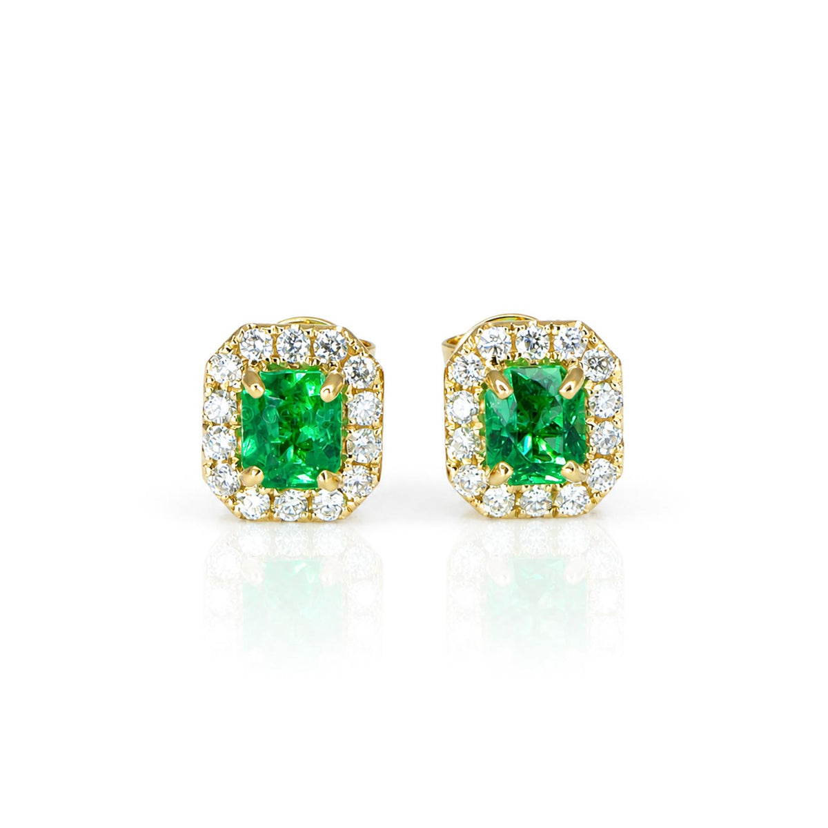 A pair of natural Colombian emerald stud earrings in yellow gold that feature emerald cut emeralds and a halo of round brilliant cut diamonds in a white background
