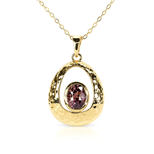 A gold pendant necklace featuring a textured, open oval design with a central oval brown sapphire gemstone, suspended from a delicate gold chain on a white background.