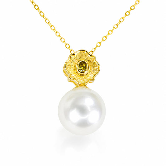 A gold pendant necklace featuring a textured flower-shaped setting with a small oval alexandrite and a large, lustrous white pearl hanging below, shown on a clean white background.