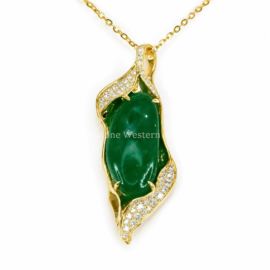 A yellow gold pendant with a cabochon emerald set in a freeform pendant adorned with diamonds shown on a white background 