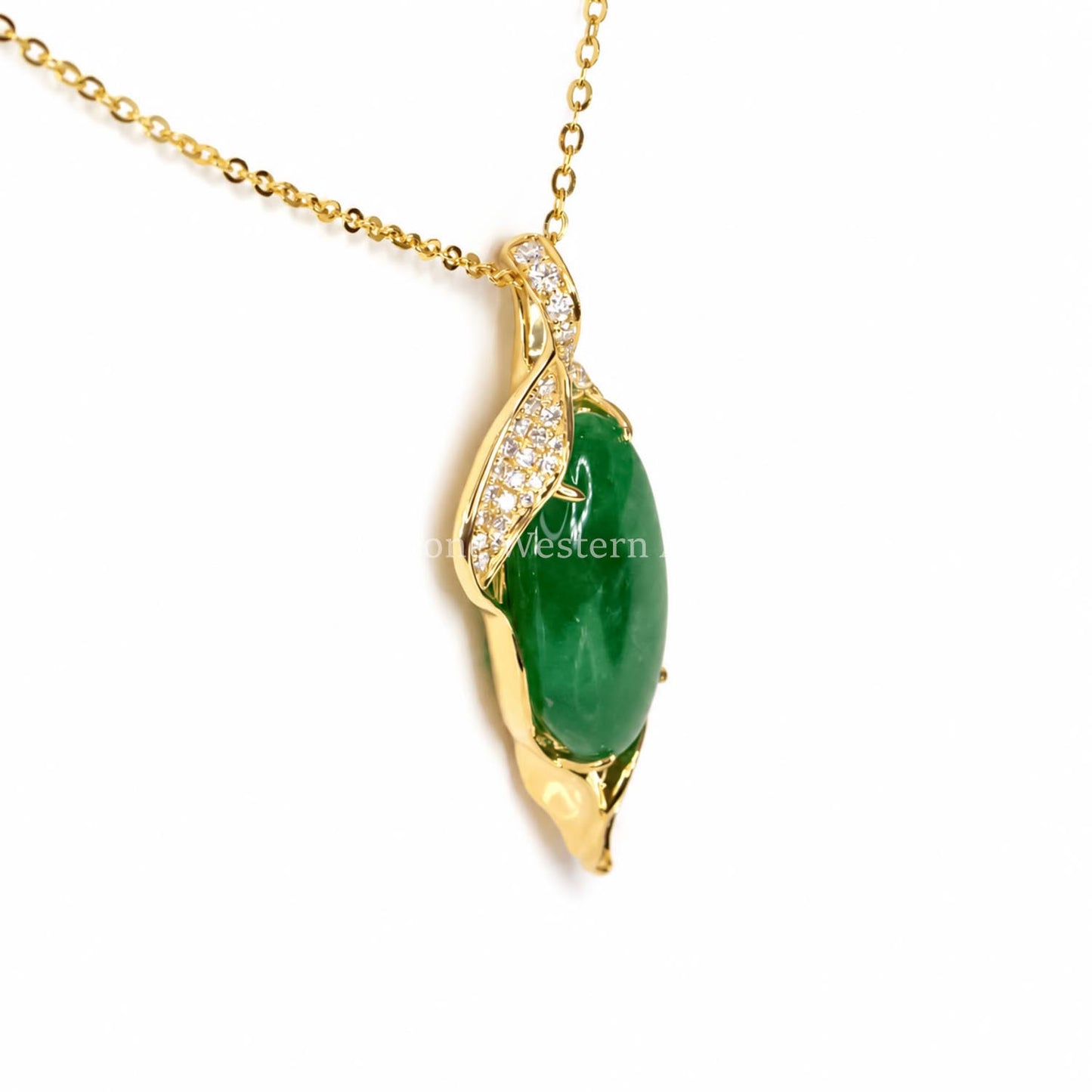 Side view of a yellow gold pendant that holds a cabochon Colombian emerald with some round diamond accent stones shown on a white background 