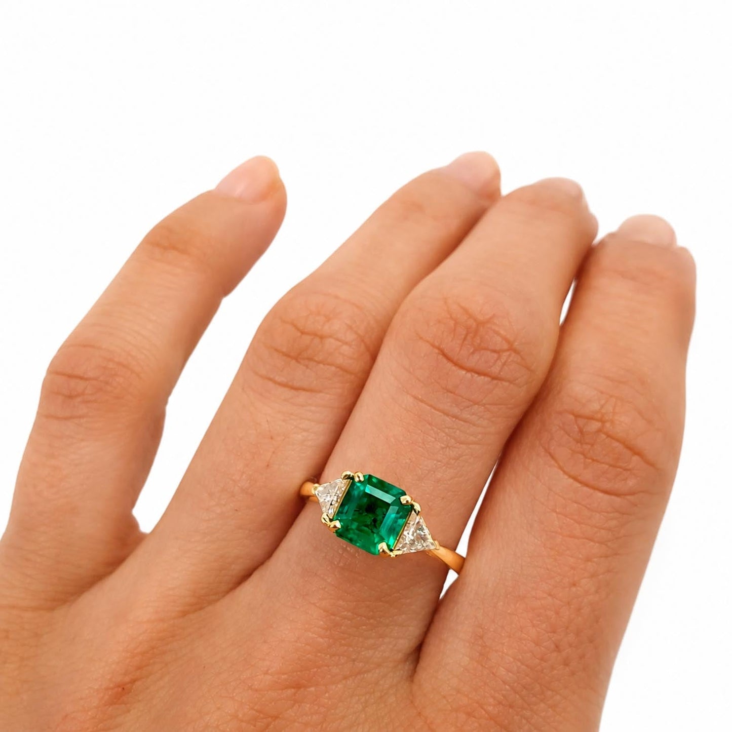 Three stone emerald ring featuring a natural Colombian emerald in 18K yellow gold