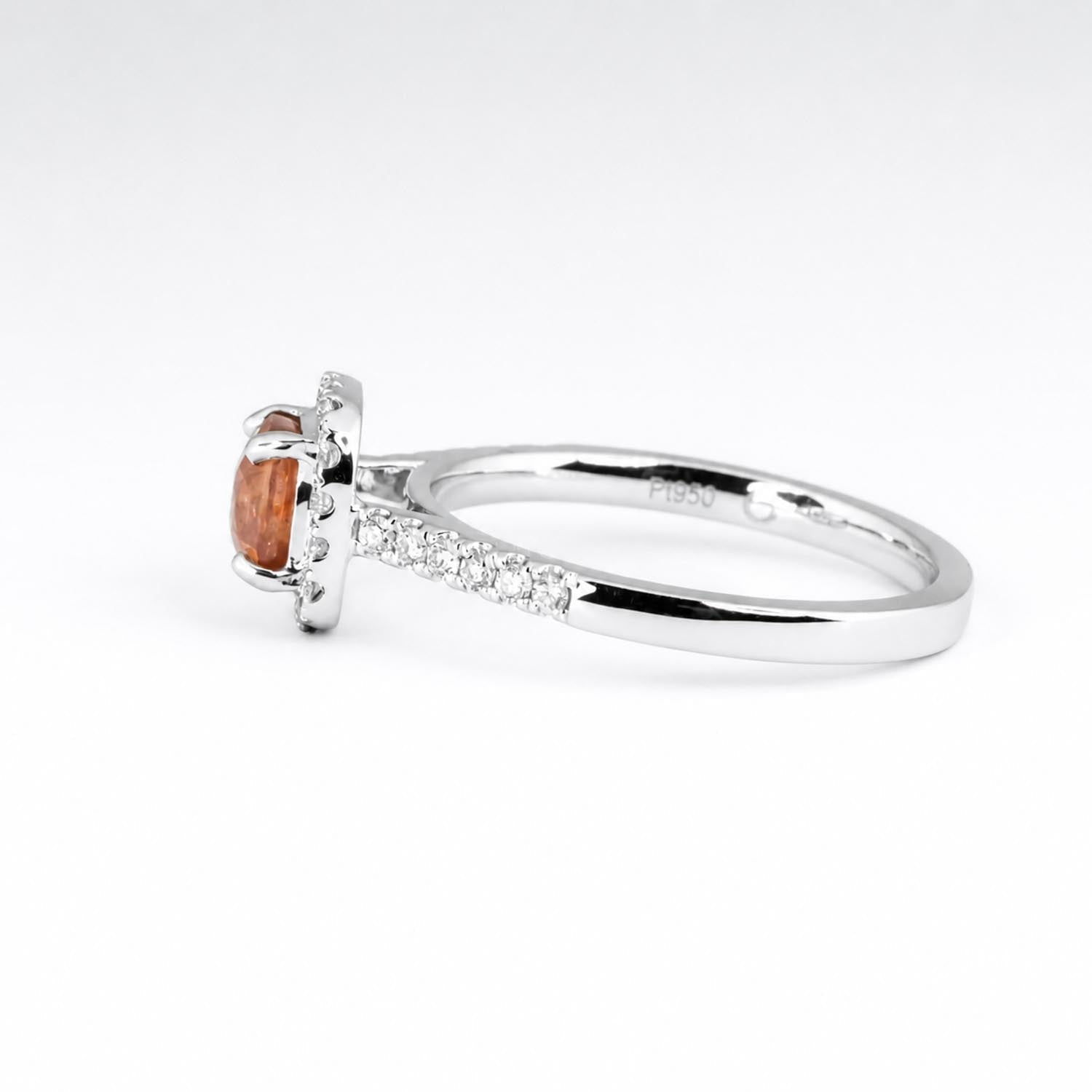 Cushion cut padparadscha sapphire ring with diamond halo in platinum