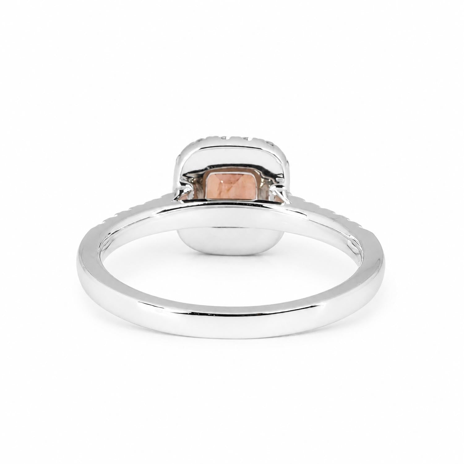 Side view of padparadscha sapphire halo ring in platinum