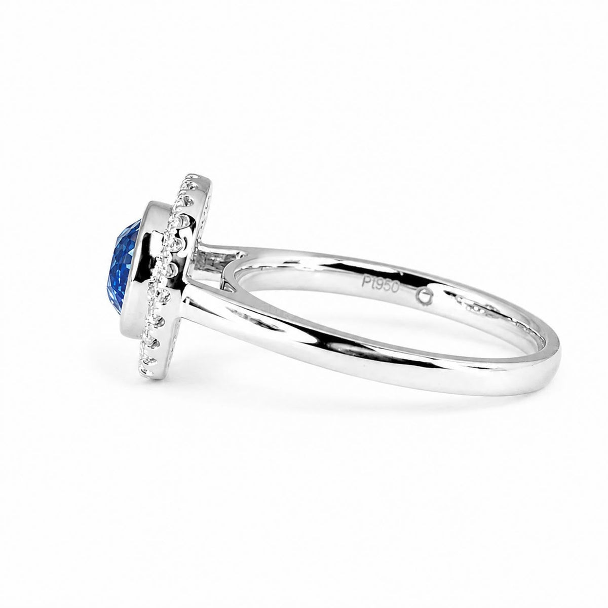 Round blue sapphire bezel set ring with diamond halo in platinum