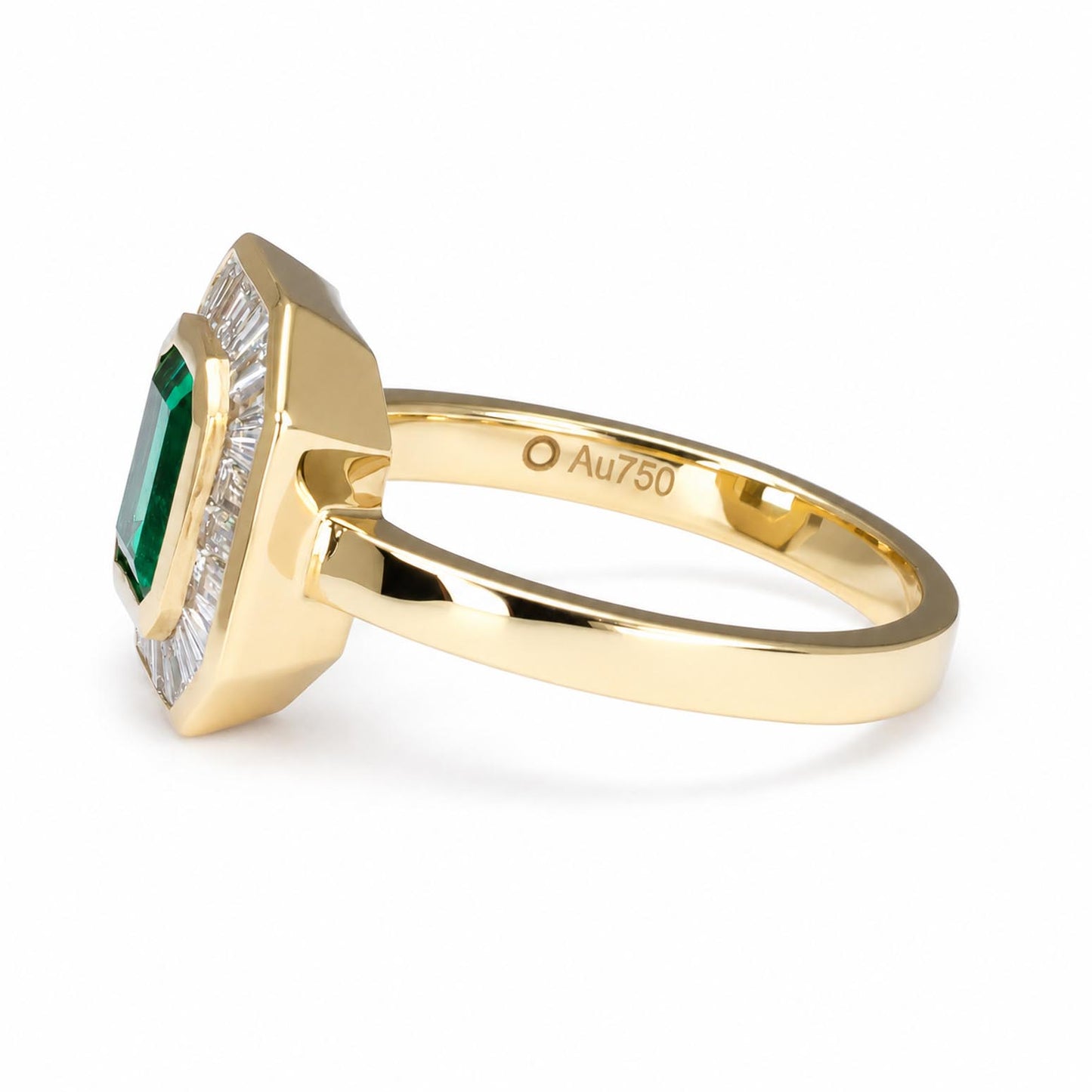 side view of a yellow gold ring featuring an emerald-cut Colombian emerald surrounded by baguette diamonds, shown on a clean white background. The inner band is engraved with 'Au750'.