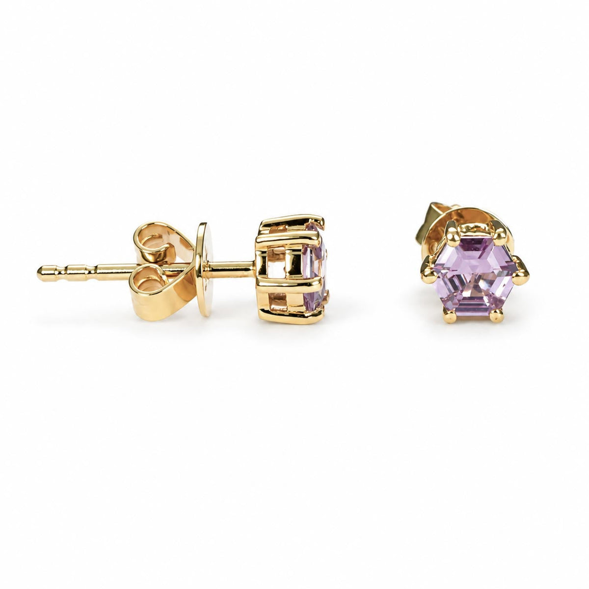 Hexagonal cut pink sapphire studs in 18K yellow gold shown at an angle