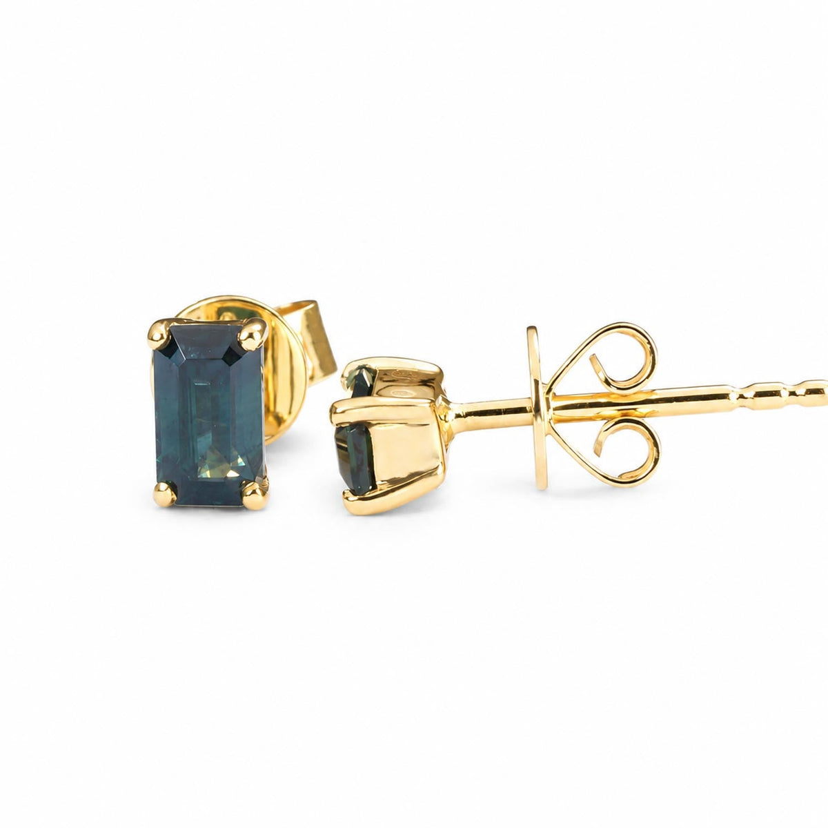 Teal sapphire emerald cut earrings in 18K yellow gold shown from the side