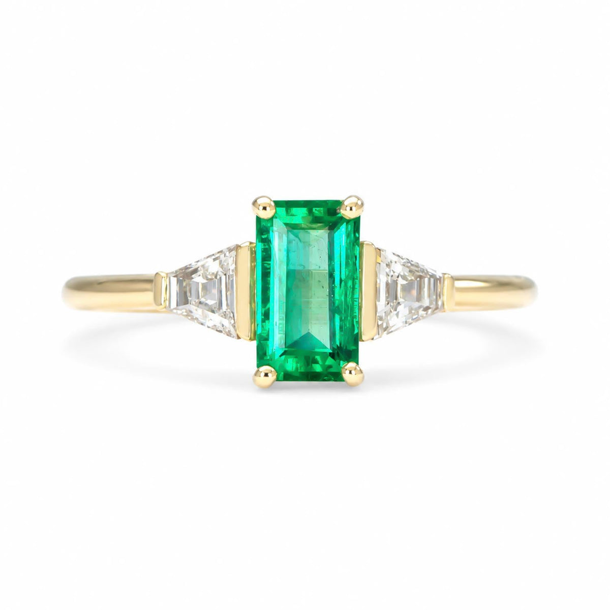 Colombian emerald ring with trapezoid diamonds shown at an angle in 18K yellow gold