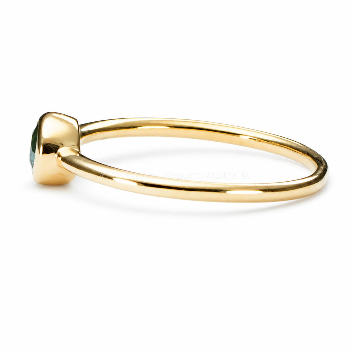 side view of an Australian sapphire yellow gold ring shown on a white background