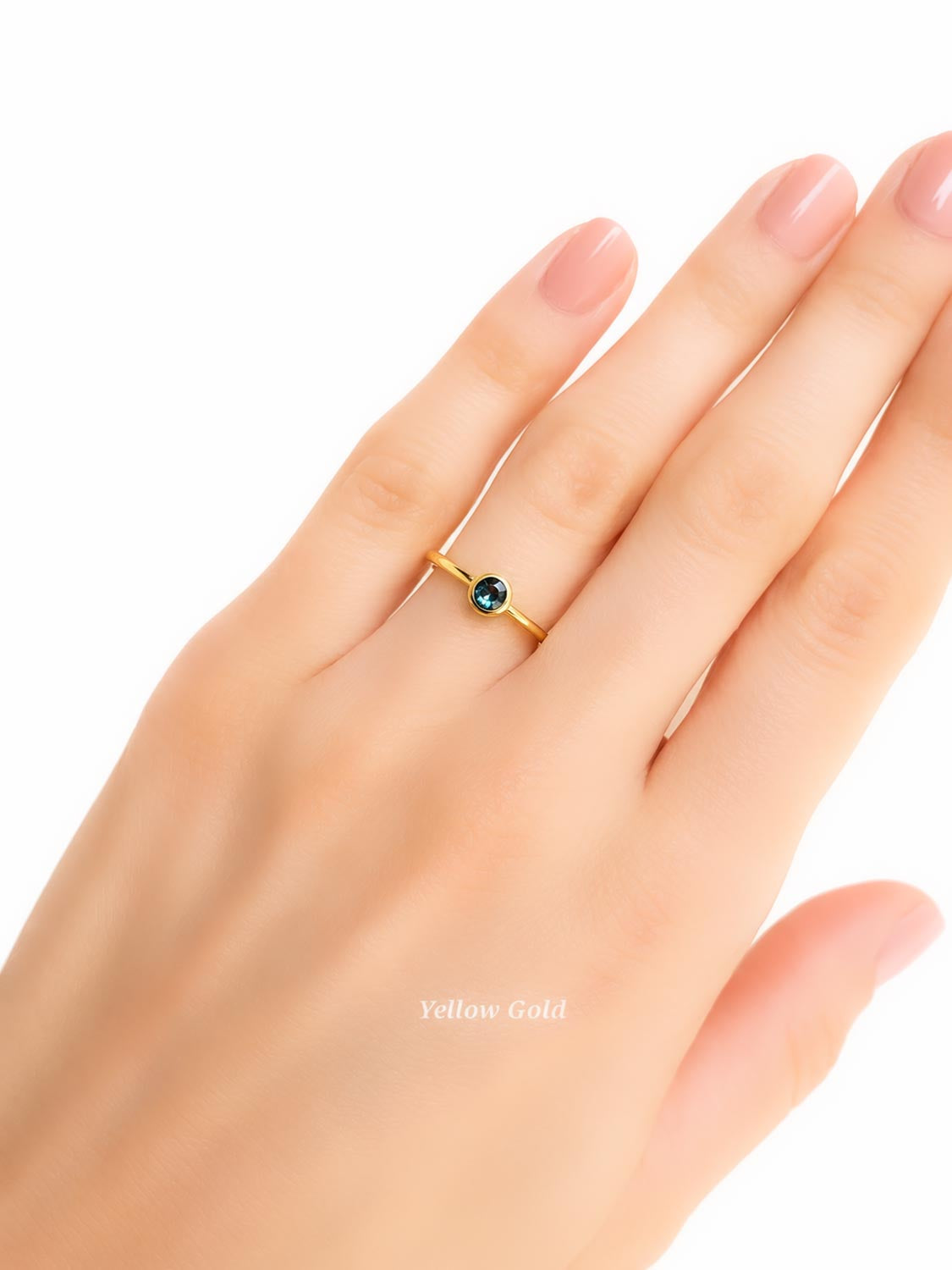 hand wearing an Australian sapphire yellow gold ring shown on a white background