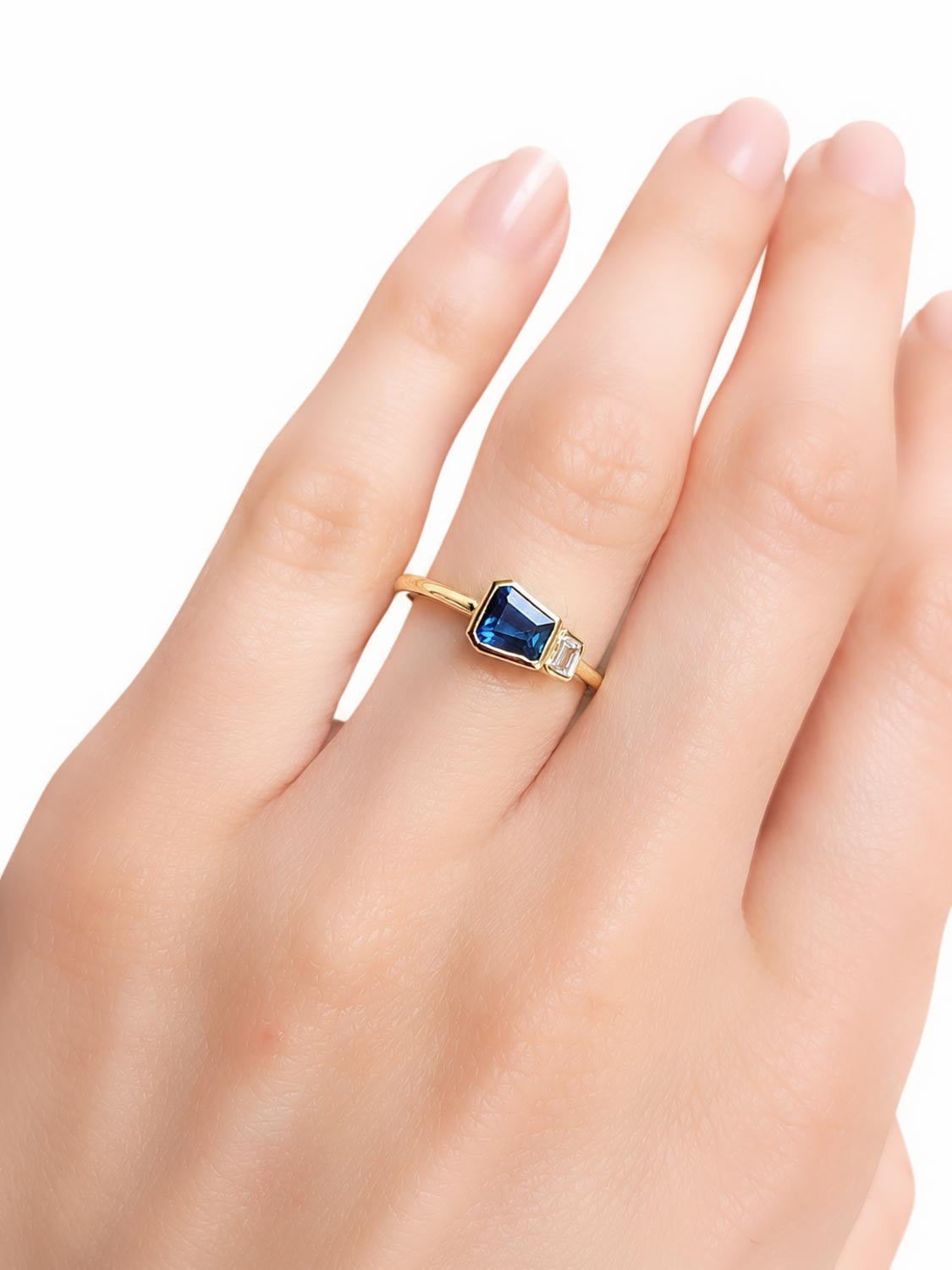 Close detail of the natural teal blue sapphire centre stone in 18K yellow gold