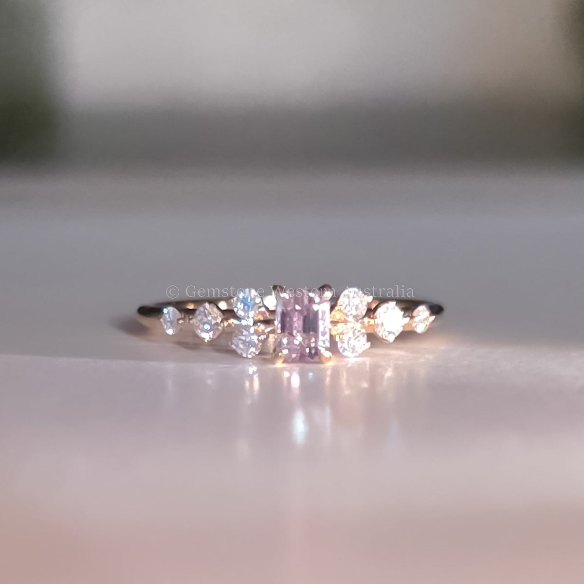 Close detail of the emerald cut natural alexandrite flanked by diamonds in 18K yellow gold