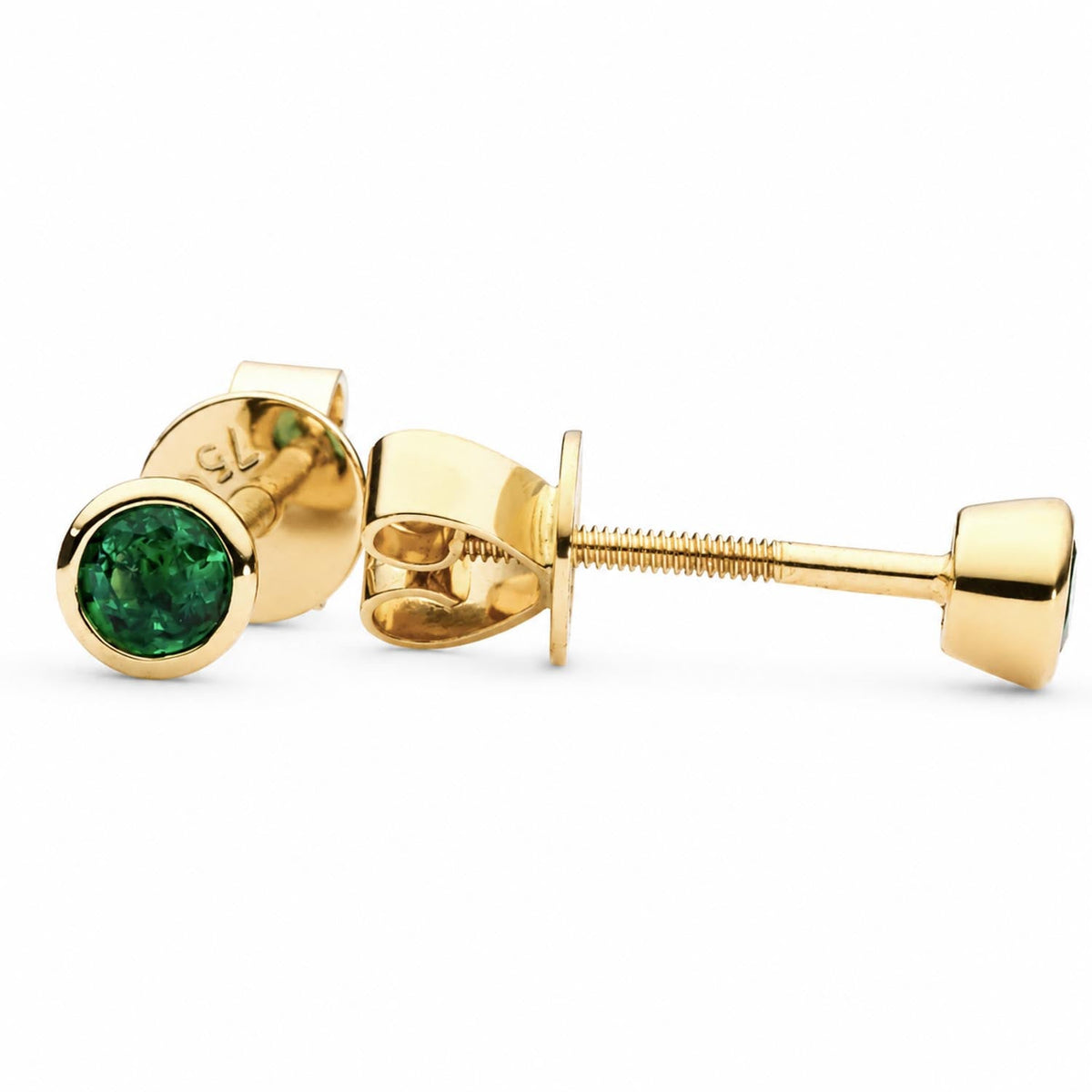 Bezel set natural emerald studs in 18K yellow gold shown at an angle